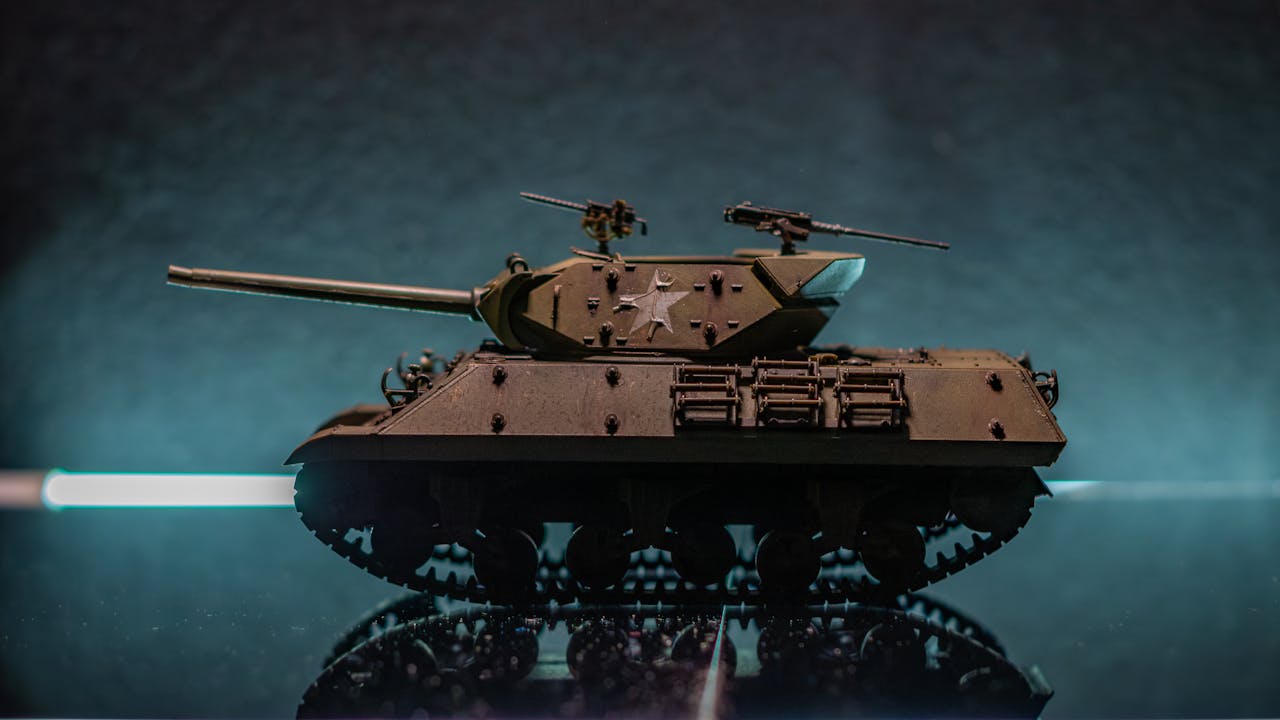 A detailed model of a military tank on a reflective surface with a dramatic background.
